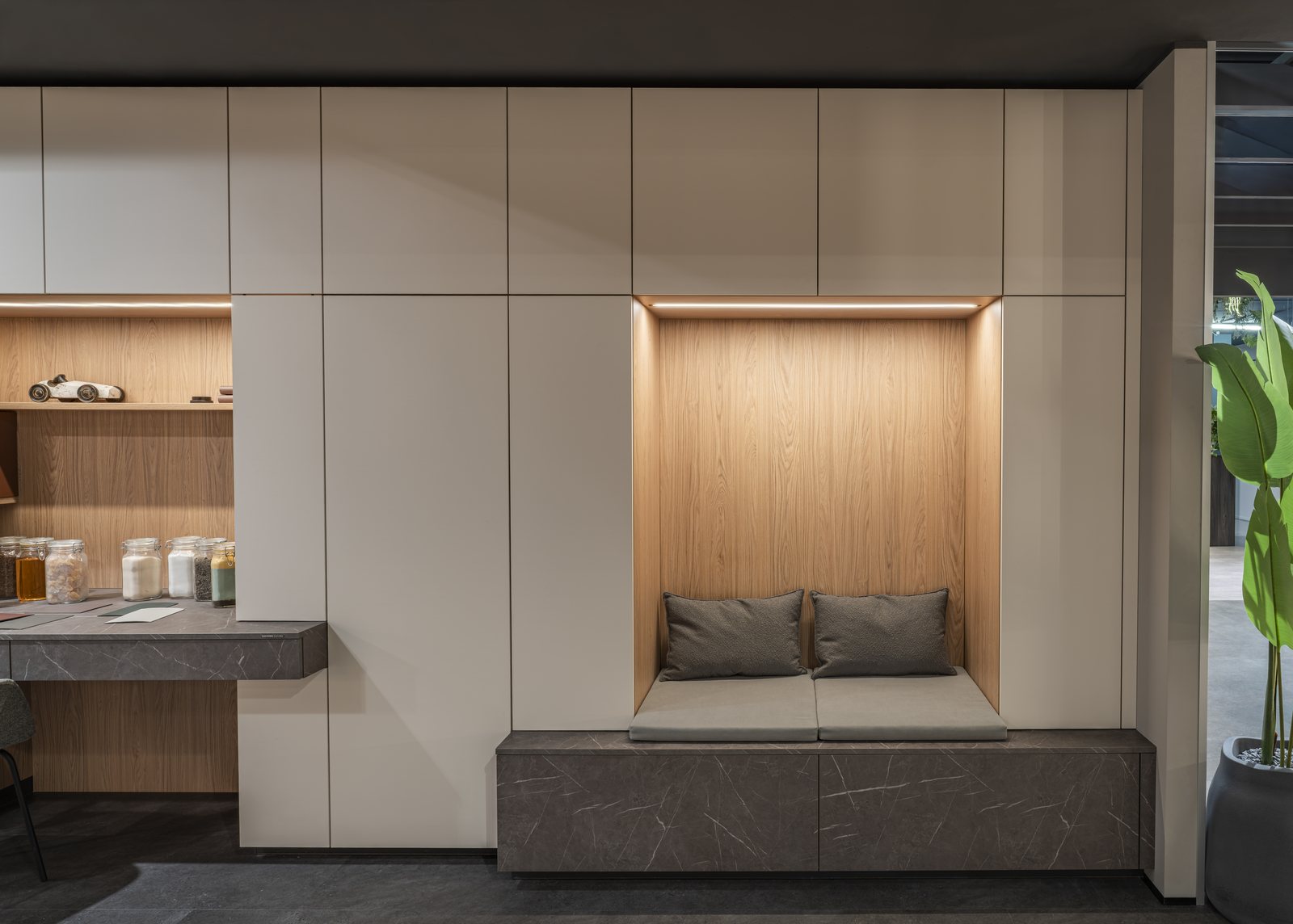 Aménagement d’entrée avec rangements intégrés, niche décorative et banquette.